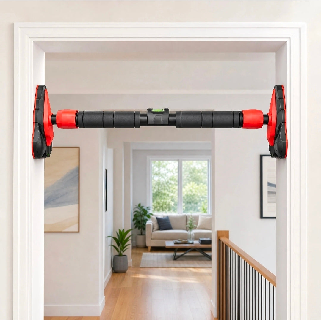 The pull-up bar mounted level inside a white doorway of a home, with the green spirit level visible in the centre of the bar.